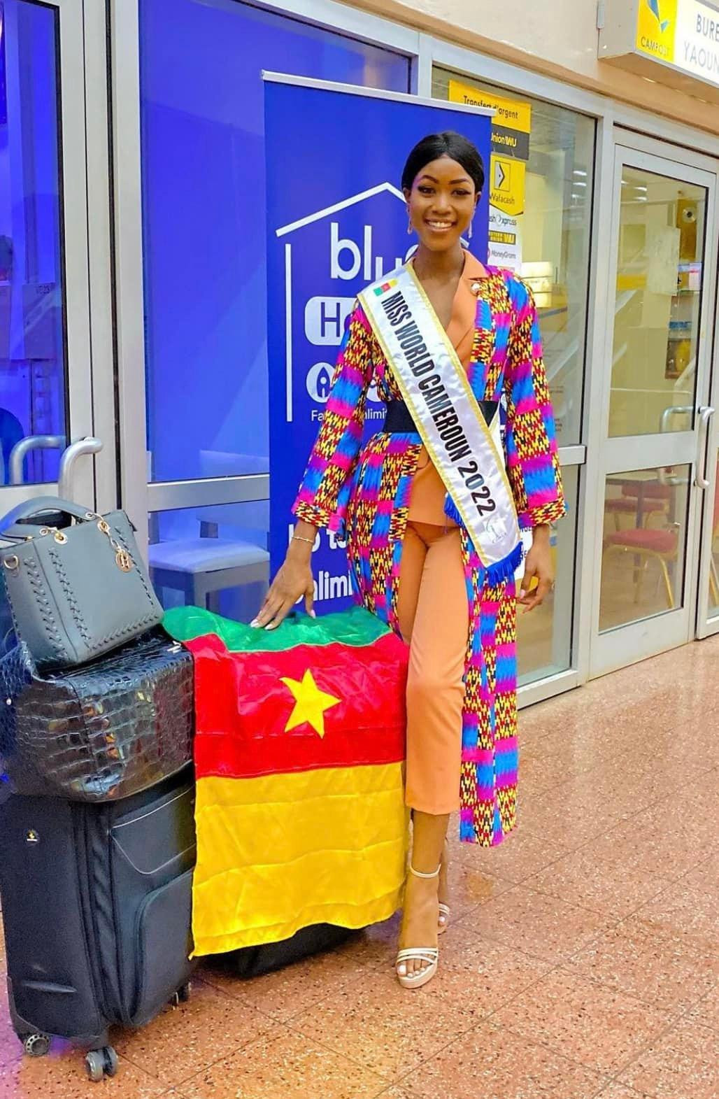 Hoa hậu Cameroon diện bộ vest cam thanh lịch, kết hợp cùng áo choàng mang hoạ tiết đặc trưng của quê hương mình khi ra sân bay.