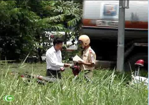 Hành vi mãi lộ ở đường Nguyễn Văn Linh của CSGT Nam Sài Gòn bị các phóng viên ghi được (ảnh cắt từ clip) 