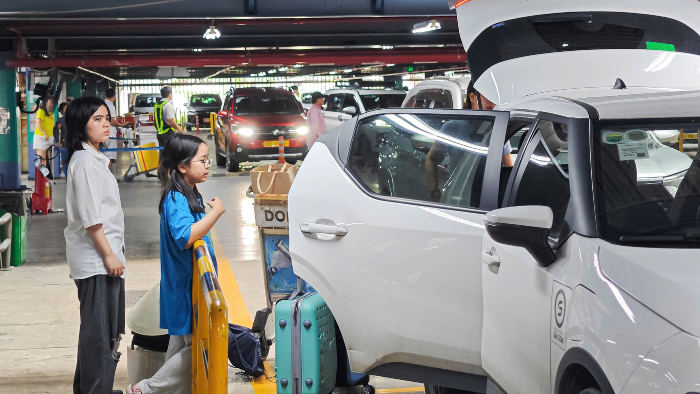 Tại khu vực chờ xe công nghệ, nhiều hành khách lỉnh kỉnh hành lý chờ xe.