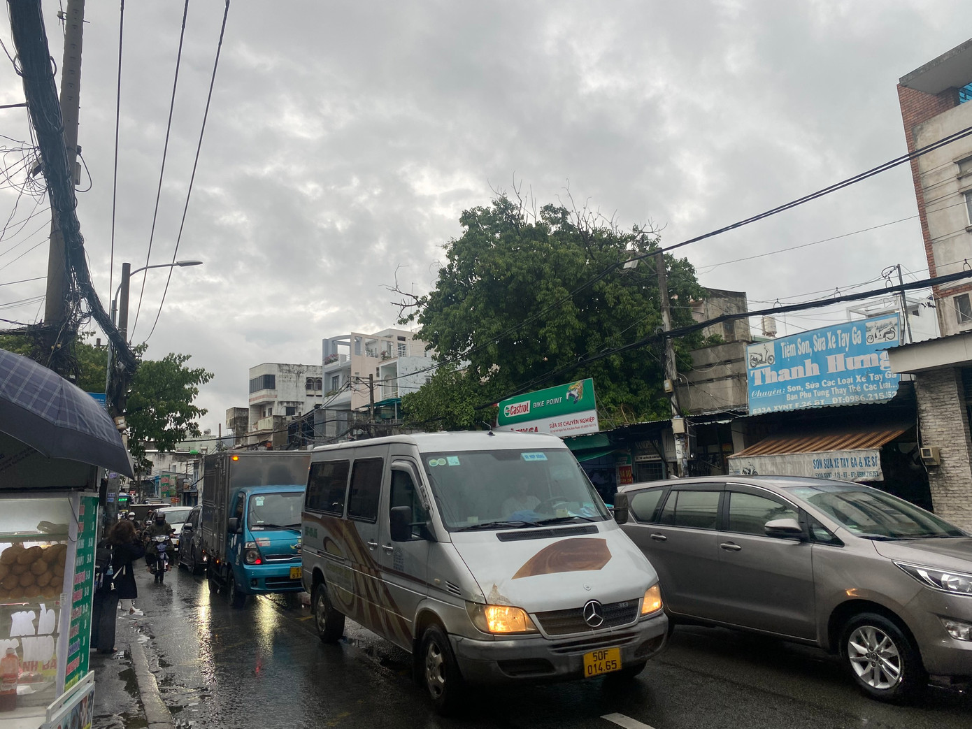 Quốc lộ 13 (quận Bình Thạnh) ùn ứ, nhiều phương tiện phải nhích từng chút một di chuyển trong mưa.