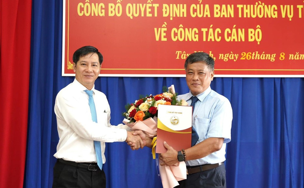 Bí thư Tỉnh ủy Tây Ninh Nguyễn Thành Tâm (trái) trao quyết định và hoa chúc mừng tân Phó trưởng ban Ban Tổ chức Tỉnh ủy Lê Anh Tuấn tại buổi lễ sáng 26/8. Ảnh: TTV11.