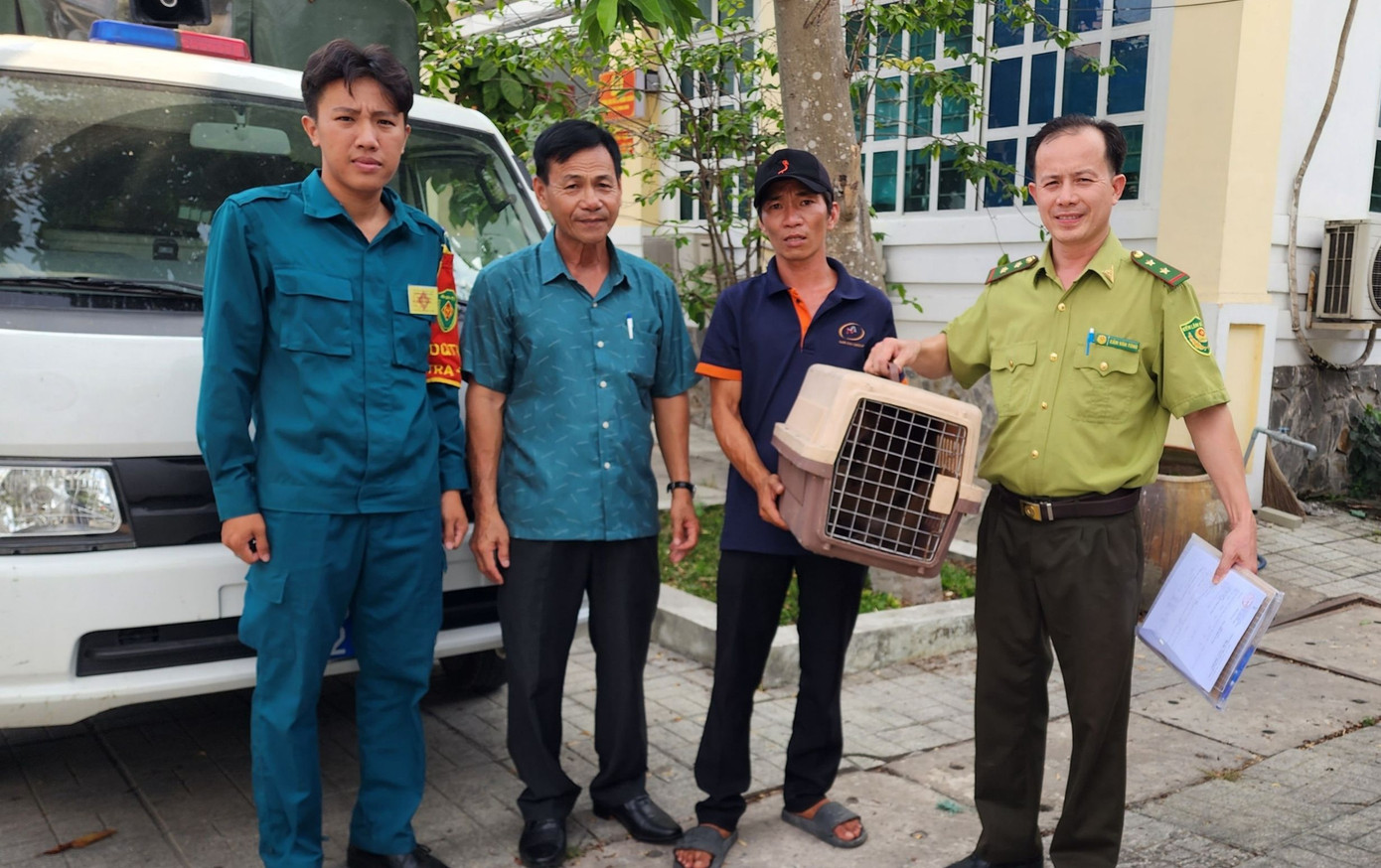 Anh Nguyễn Văn Để (ngụ xã Lê Minh Xuân, huyện Bình Chánh, thứ 3 từ trái sang) giao nộp khỉ mặt đỏ cho cơ quan chức năng