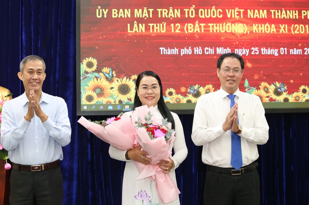 Ông Võ Văn Thiện (trái) - Trưởng ban Công tác phía Nam, Ủy ban Trung ương MTTQ Việt Nam và ông Nguyễn Thành Trung - Phó Chủ tịch Thường trực Ủy ban MTTQ Việt Nam TPHCM tặng hoa chúc mừng bà Nguyễn Thị Kim Thúy. Ảnh: Ngô Tùng