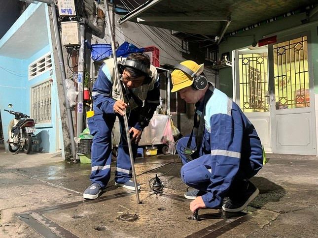 Công nhân tổ dò bể thuộc Ban quản lý giảm nước không doanh thu Công ty CP Cấp nước Bến Thành (Tổng Công ty Cấp nước Sài Gòn - SAWACO) kiểm tra đường ống nước. Ảnh: Uyên Phương.