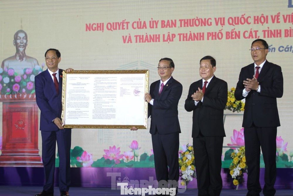 Phó Chủ tịch Quốc hội Trần Quang Phương (bìa trái) trao Nghị quyết về việc thành lập thành phố Bến Cát