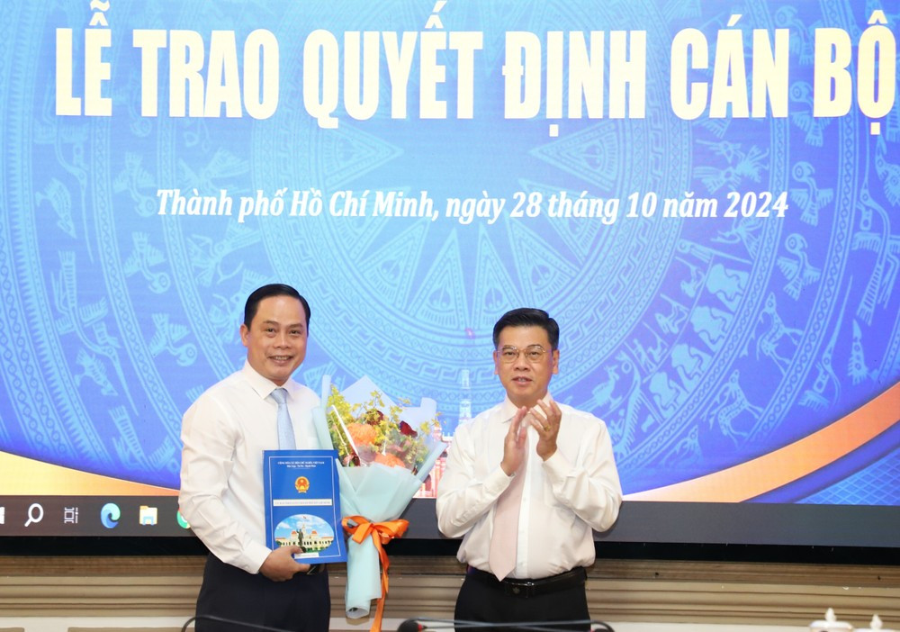 Phó Chủ tịch UBND TPHCM Nguyễn Văn Dũng (phải) trao quyết định cho ông Nguyễn Huy Thắng. Ảnh: Ngô Tùng