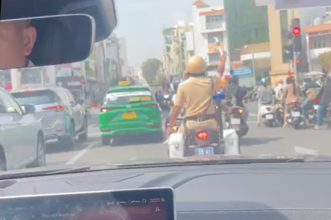 CSGT ra hiệu lệnh cho các phương tiện di chuyển để ô tô chở bé gái sơ sinh đi qua. Ảnh cắt từ clip. CSGT ra hiệu lệnh cho các phương tiện di chuyển để ô tô chở bé gái sơ sinh đi qua. Ảnh cắt từ clip.