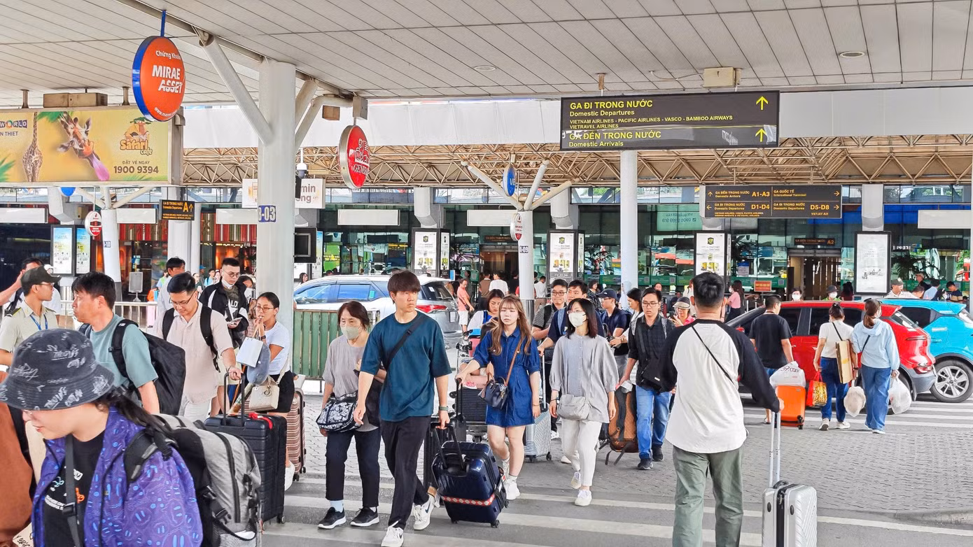 Nhiều hành khách lỉnh kỉnh hành lý, vội vàng di chuyển để kịp chuyến bay.