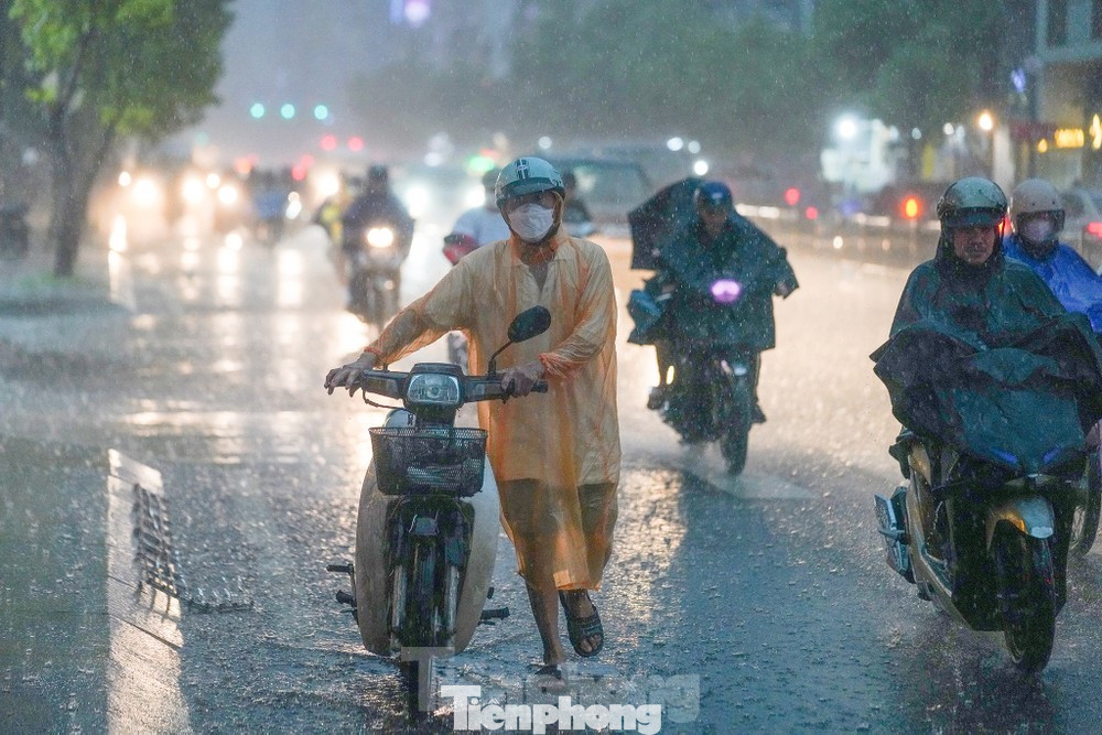Người dân di chuyển trong cơn mưa lớn tại TPHCM. Ảnh: Phạm Nguyễn Người dân di chuyển trong cơn mưa lớn tại TPHCM. Ảnh: Phạm Nguyễn