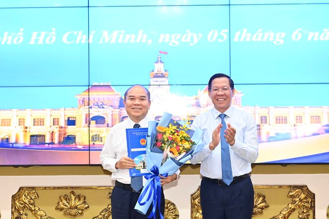 Chủ tịch UBND TPHCM Phan Văn Mãi (bên phải) trao quyết định và hoa chúc mừng ông Trần Văn Bảy. Ảnh: Việt Dũng Chủ tịch UBND TPHCM Phan Văn Mãi (bên phải) trao quyết định và hoa chúc mừng ông Trần Văn Bảy. Ảnh: Việt Dũng