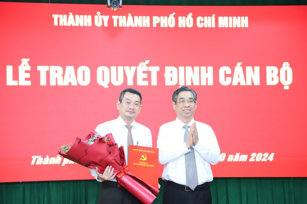 Phó Bí thư Thành ủy TPHCM Nguyễn Phước Lộc (bên phải) trao quyết định cho ông Hoàng Minh Tuấn Anh. Ảnh: Ngô Tùng