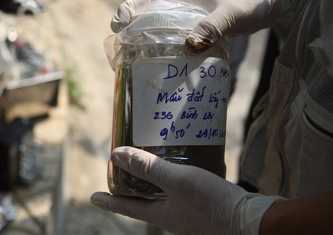 Các chuyên gia tiến hành lấy mẫu đất, khí xét nghiệm.. Các chuyên gia tiến hành lấy mẫu đất, khí xét nghiệm.