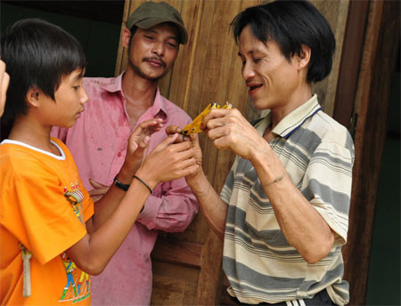 Anh Loan đã dần quen với cuộc sống cộng động, anh đang chơi bắn ná thun với cháu