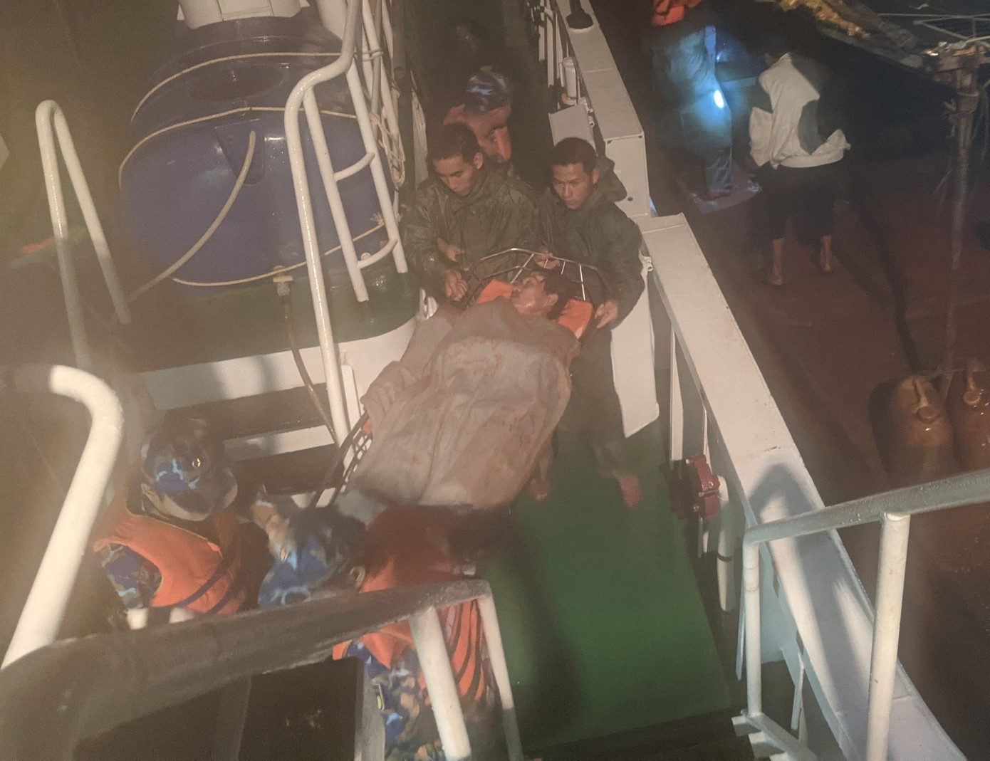 Cán bộ, chiến sĩ Tàu 468 đưa ngư dân Nguyễn Văn Nhân lên tàu điều trị. Ảnh: Nguyễn Nam.