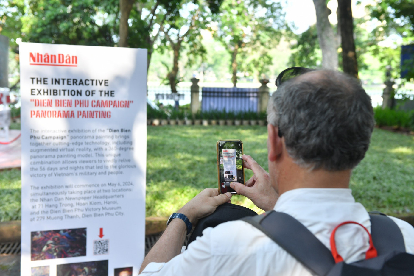Du khách sử dụng điện thoại, máy tính bảng quét mã QR và trải nghiệm công nghệ AR ẩn trong bức tranh.
