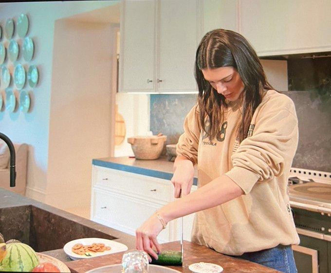 Nàng người mẫu để chéo tay và bắt đầu cắt từng lát dưa leo.