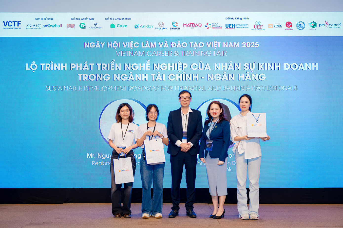 Ông Nguyễn Hoàng Anh Vũ – Giám đốc Khu vực TP.HCM (giữa) và Bà Phạm Thị Hương Hạnh – Giám đốc tuyển dụng Vietbank (thứ hai từ phải sang) trao quà cho người tham dự tại sự kiện.