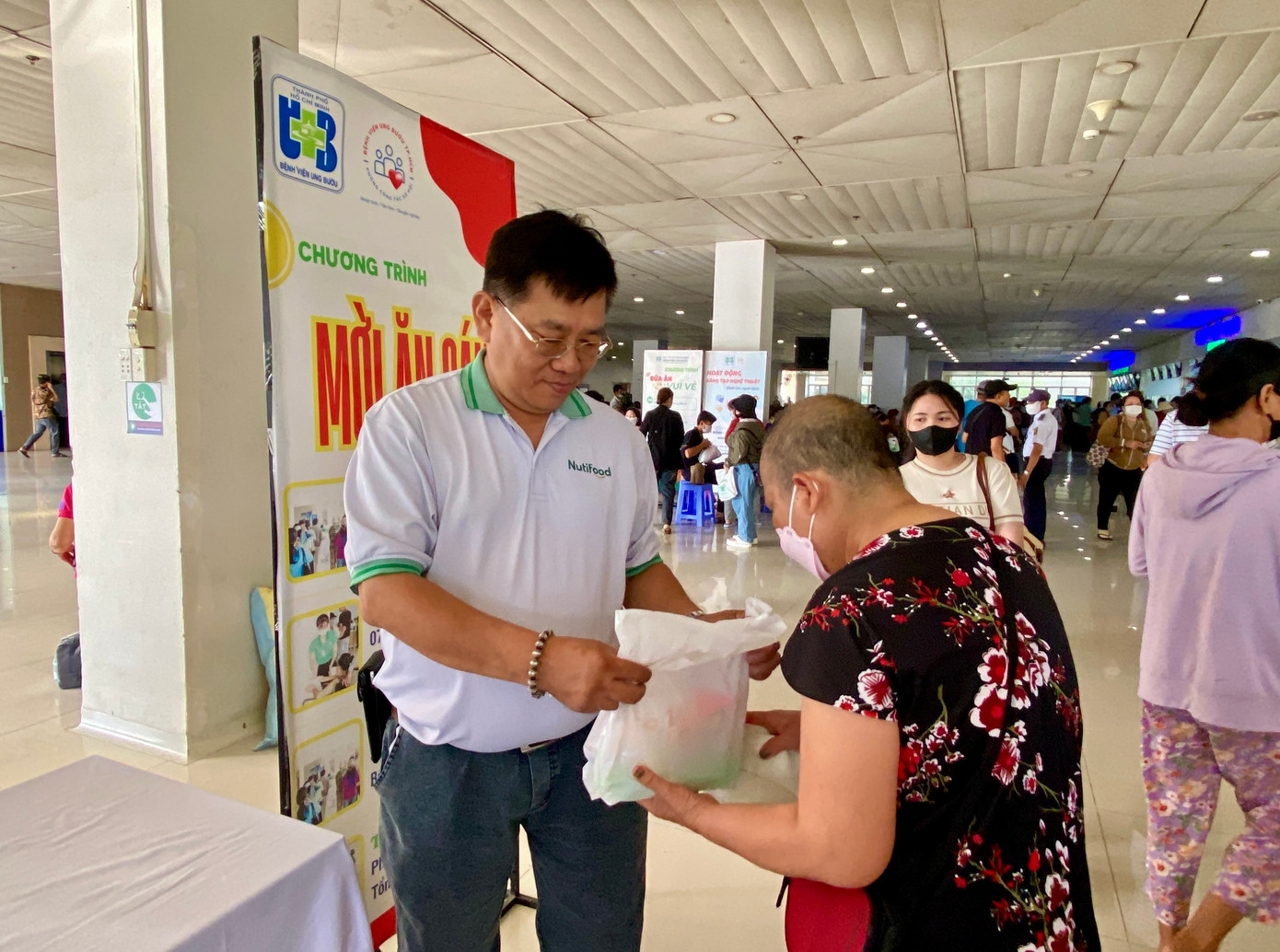Anh Trần Hữu Đức - Trưởng Bộ phận Quan hệ Cộng đồng đại diện Nutifood trao các phần ăn cho các bệnh nhân