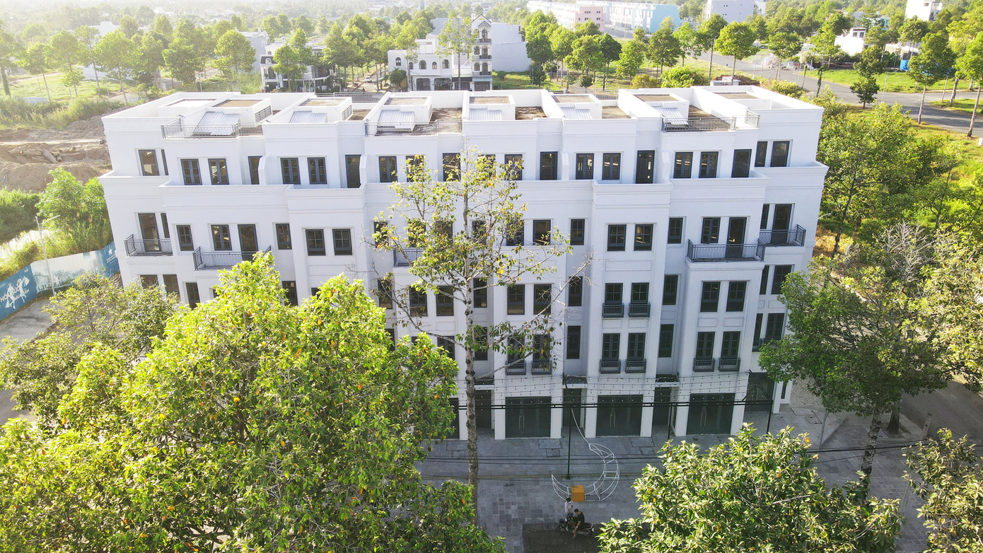 Một dãy nhà phố thương mại xen lẫn giữa hàng cây xanh tại KITA Airport City