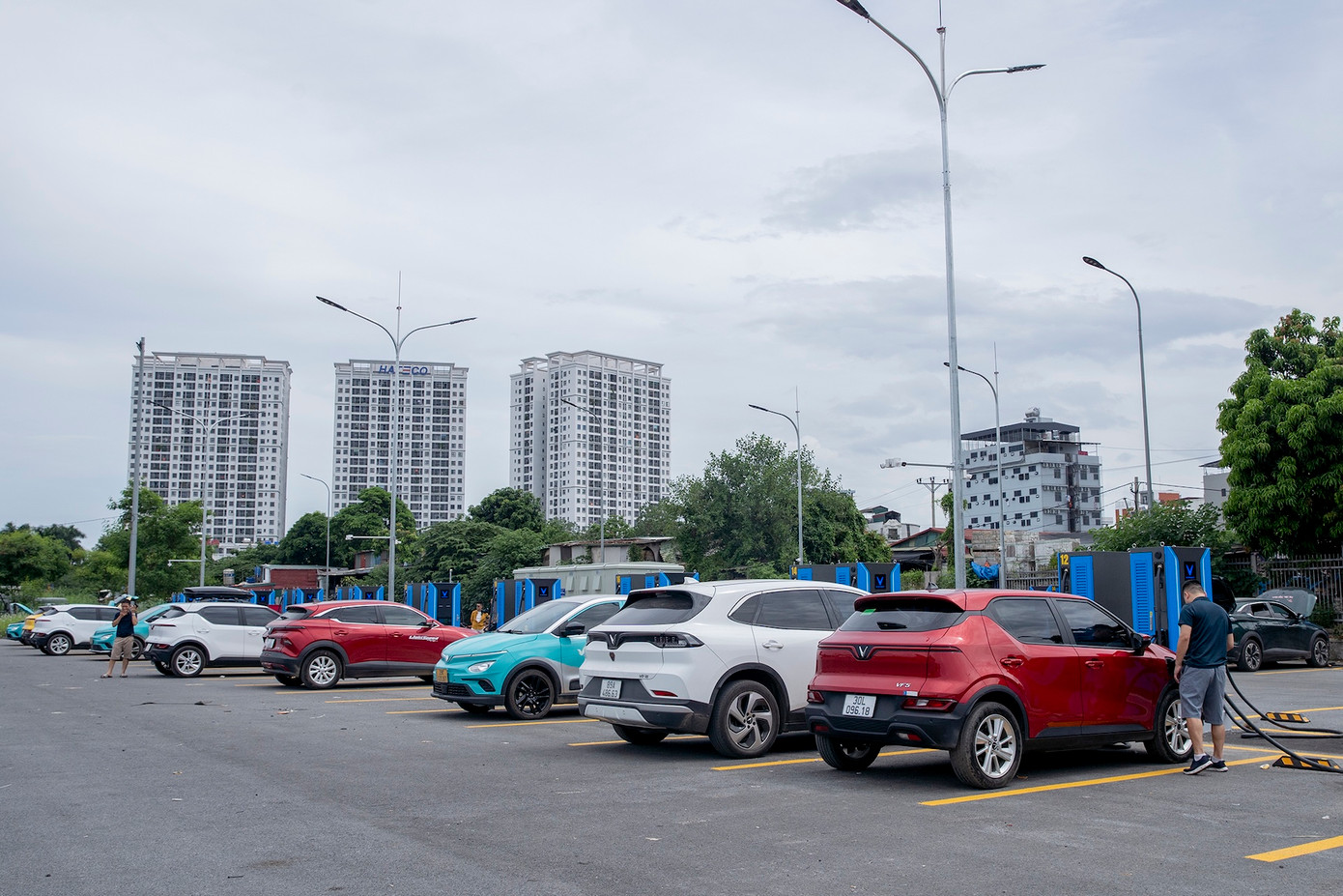Trạm sạc này tọa lạc tại bãi đỗ xe Minh Khai (đường Cầu Diễn, quận Nam Từ Liêm). Đây là trục đường huyết mạch, ở cửa ngõ Thủ đô, kết nối với quốc lộ 32 đi các tỉnh Tây Bắc.