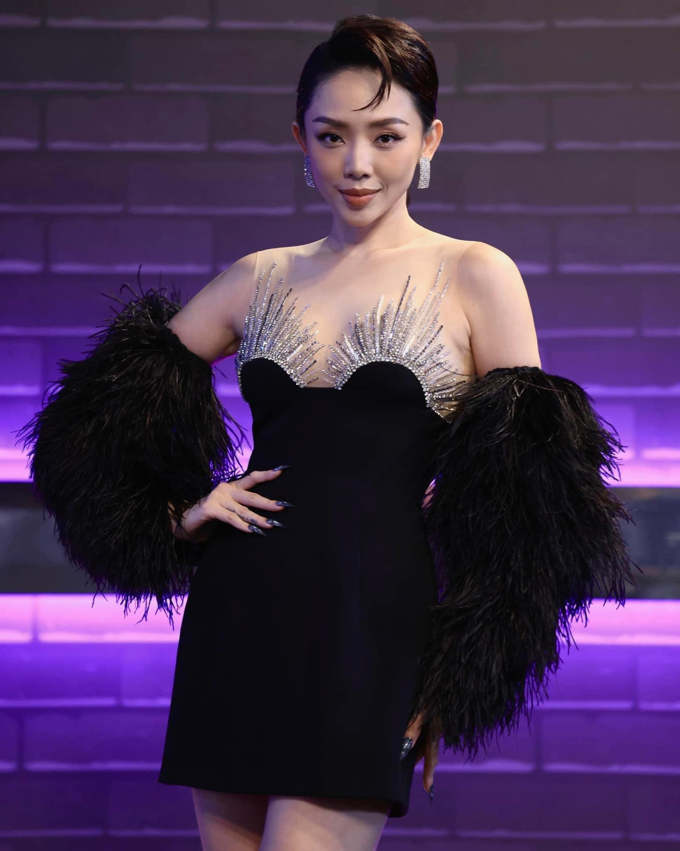 Điểm nhấn của thiết kế là chi tiết đính đá lấp lánh ở ngực váy, đi kèm lông vũ kiêu sa, thanh lịch.