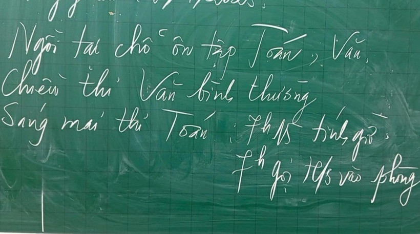Giáo viên viết lên bảng thông báo học sinh ngồi tại chỗ ôn tập trong giờ kiểm tra môn Toán học kỳ I ở TP Thái Bình.