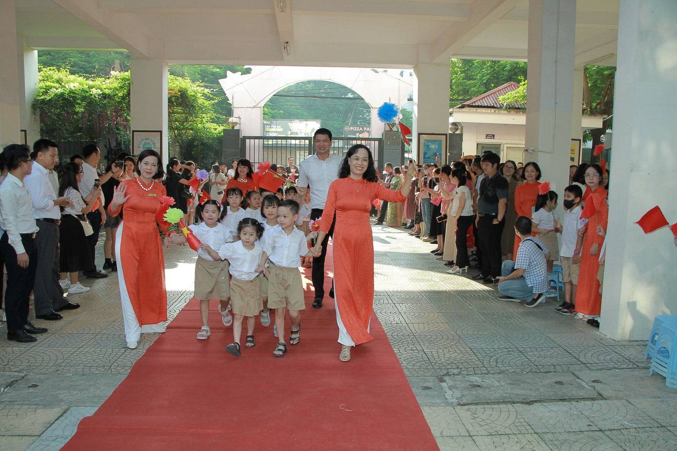 Các bạn học sinh lớp 1 được thầy cô dẫn dắt tiến vào sân trường.