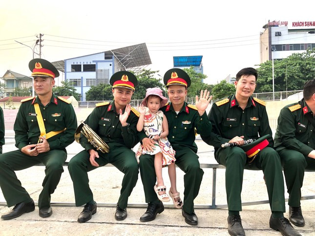 Bé Vy Trâm cùng các chú bộ đội trong giờ giải lao.