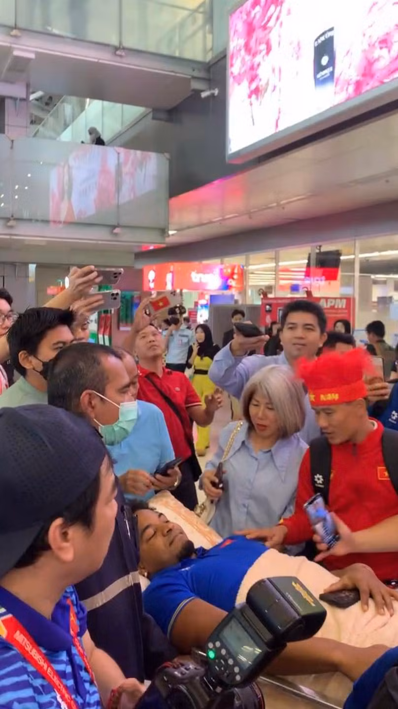 Xuân Son nằm cáng để ra sân bay. (Ảnh cắt từ livestream Facebook Hoàng Trung)