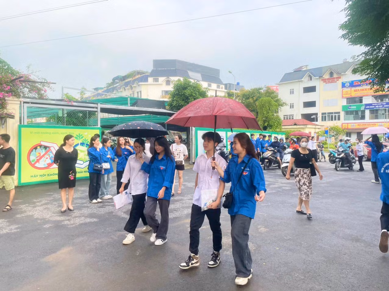 Các thanh niên tình nguyện hỗ trợ, động viên thí sinh tại điểm thi ở quận Hà Đông. (Ảnh: Hiền Vũ)