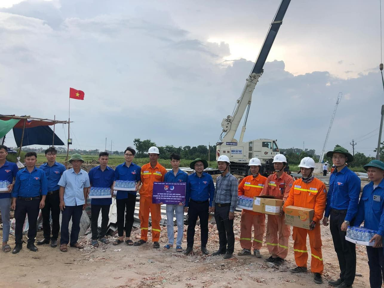 Anh Nguyễn Bá Cát - Phó Bí thư Tỉnh Đoàn Thái Bình (bìa trái) tặng nước và sữa cho đội hình thanh niên xung kích hỗ trợ thi công đường dây 500kV mạch 3.