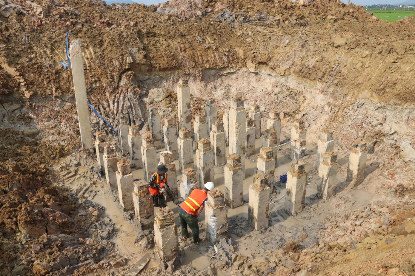 Công nhân nhà thầu phá đầu cọc vị trí móng cọc.