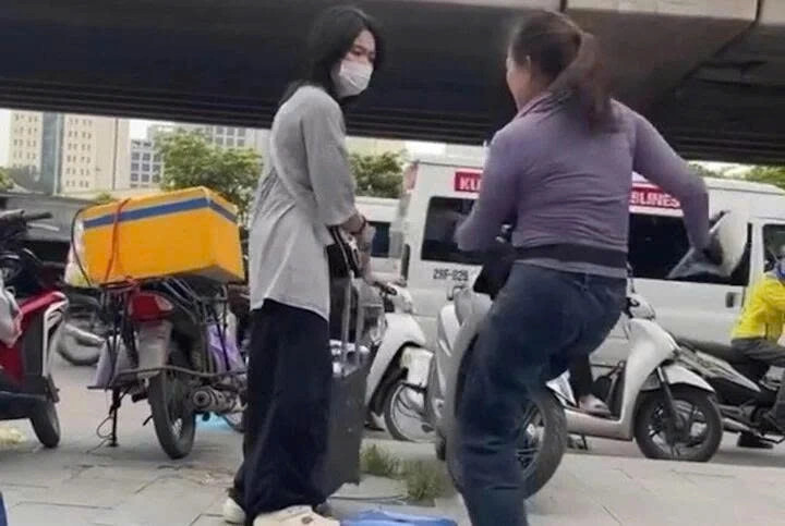 Bà K. đuổi cô gái đang đứng chờ xe trên vỉa hè. (Ảnh chụp màn hình)