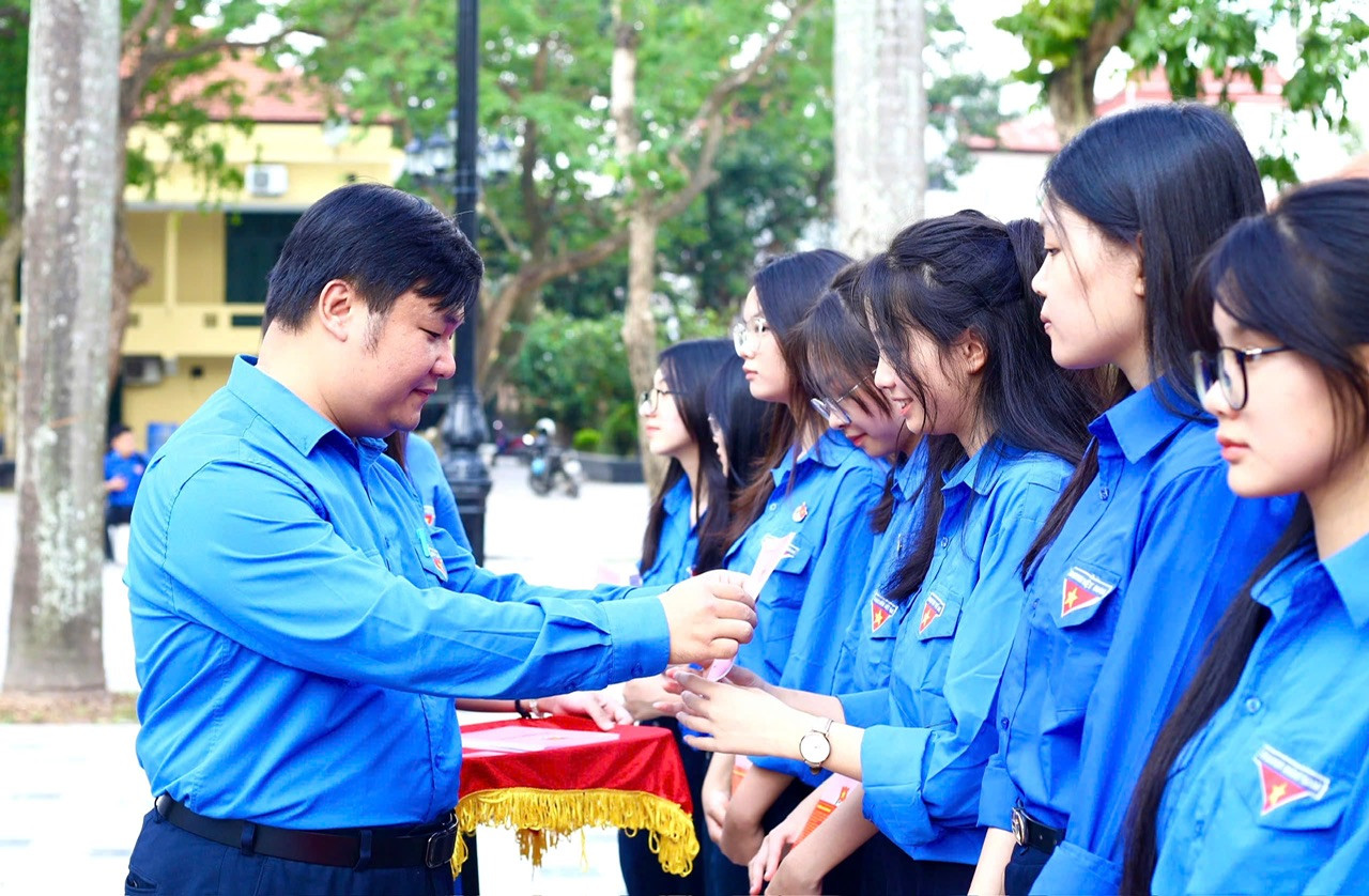 Đồng chí Nguyễn Thái An, Trưởng Ban Tuyên giáo Trung ương Đoàn trao Sổ đoàn và Huy hiệu đoàn cho học sinh lớp Đoàn viên 110 năm Ngày sinh anh Lý Tự Trọng.