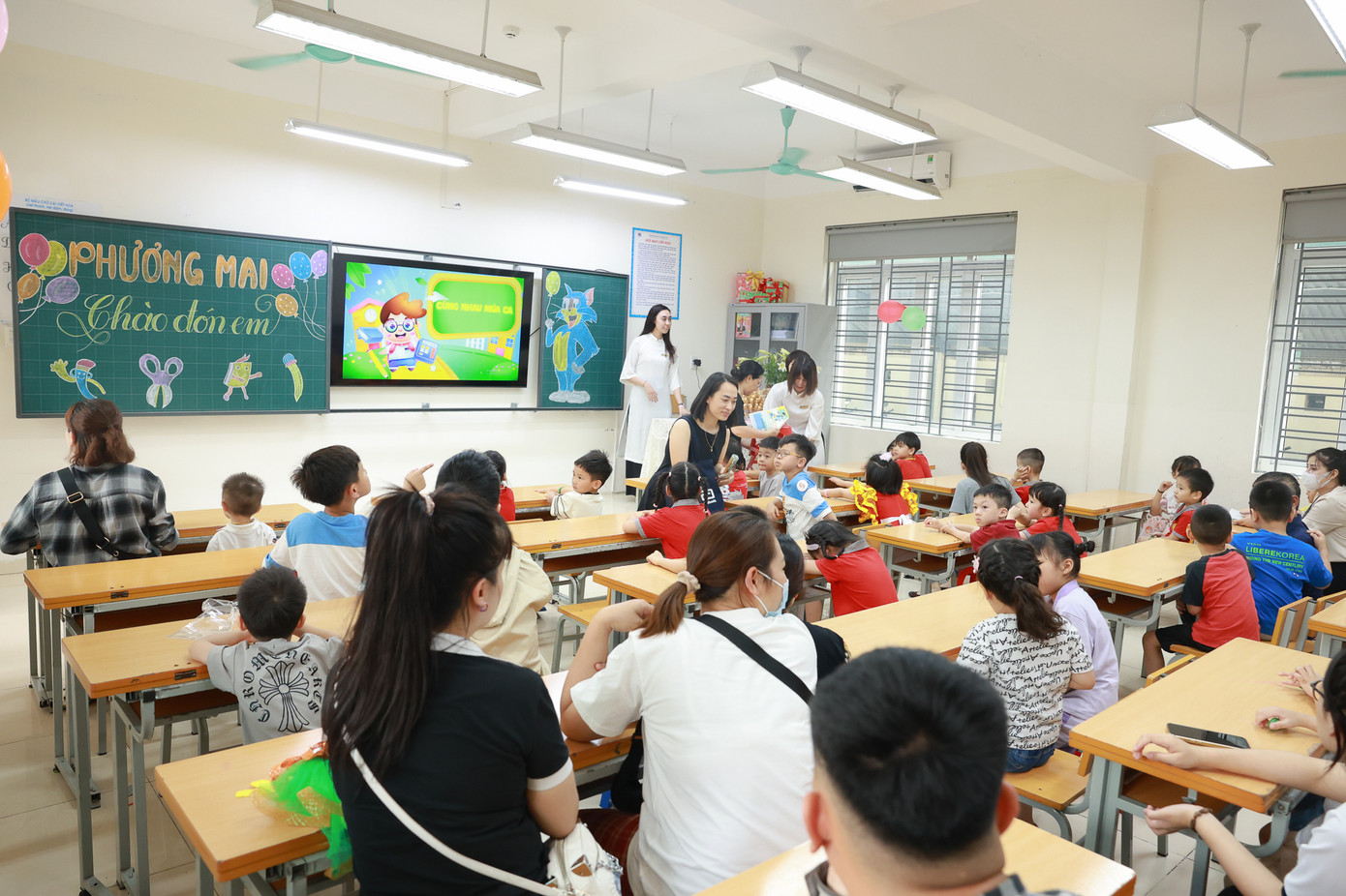 Các bạn nhỏ và phụ huynh trải nghiệm trong lớp học của trường.