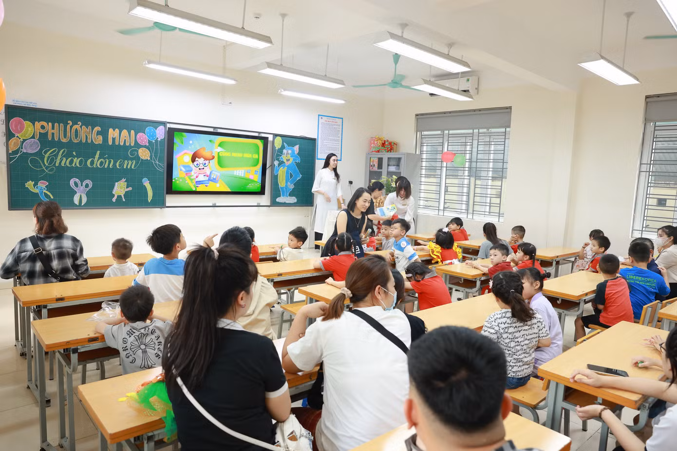Các bạn nhỏ và phụ huynh trải nghiệm trong lớp học của trường.