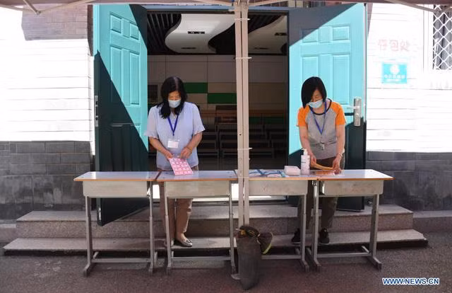 Các nhân viên chuẩn bị bàn gửi túi xách tại điểm thi ở Bắc Kinh. (Ảnh: Tân Hoa Xã) Các nhân viên chuẩn bị bàn gửi túi xách tại điểm thi ở Bắc Kinh. (Ảnh: Tân Hoa Xã)