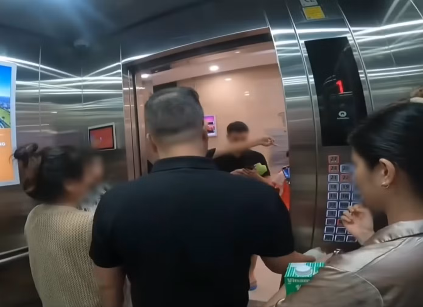 Ảnh cắt từ clip vụ gia đình PTTC tìm tai nghe trong thang máy.