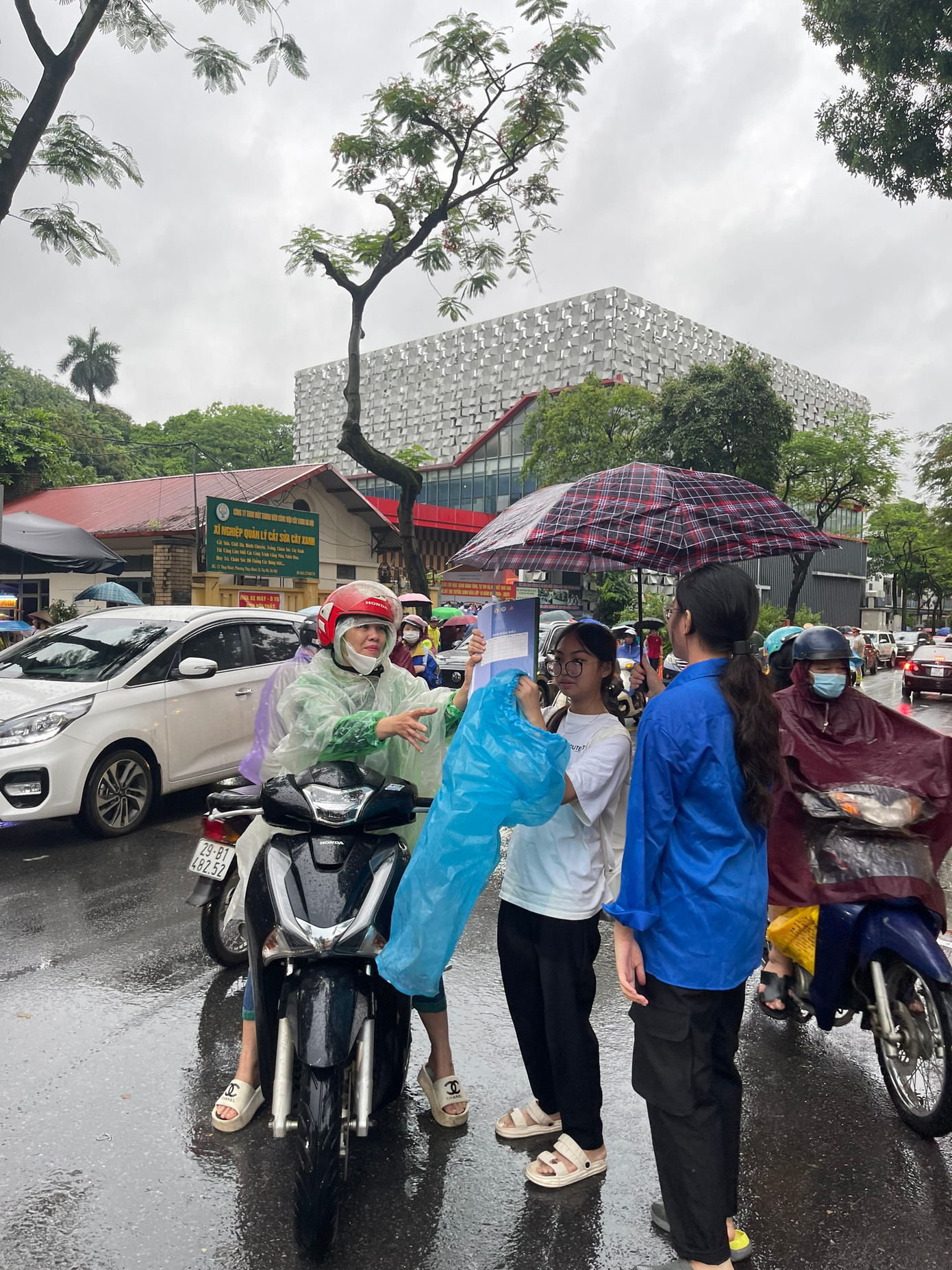 Thí sinh và phụ huynh Hà Nội đội mưa đi thi sáng 9/6 tại điểm thi THCS Chu Văn An. (Ảnh: Hiền Vũ)