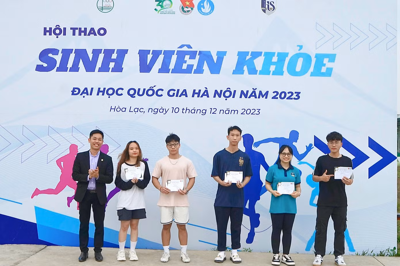 Đồng chí Tưởng Văn Thuấn - Chủ tịch Hội Sinh viên Đại học Quốc gia Hà Nội trao Giấy chứng nhận cho các bạn sinh viên đạt được kỷ lục tại các nội dung thi.