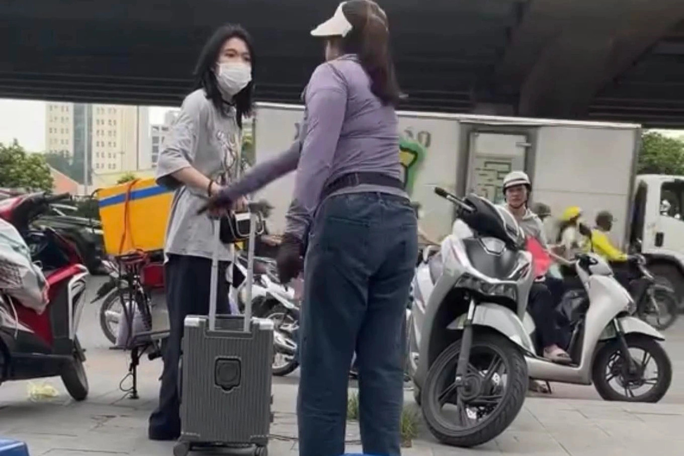 Người bán trà đá đuổi cô gái đứng ở vỉa hè bến xe Mỹ Đình. (Ảnh cắt từ clip) Người bán trà đá đuổi cô gái đứng ở vỉa hè bến xe Mỹ Đình. (Ảnh cắt từ clip)