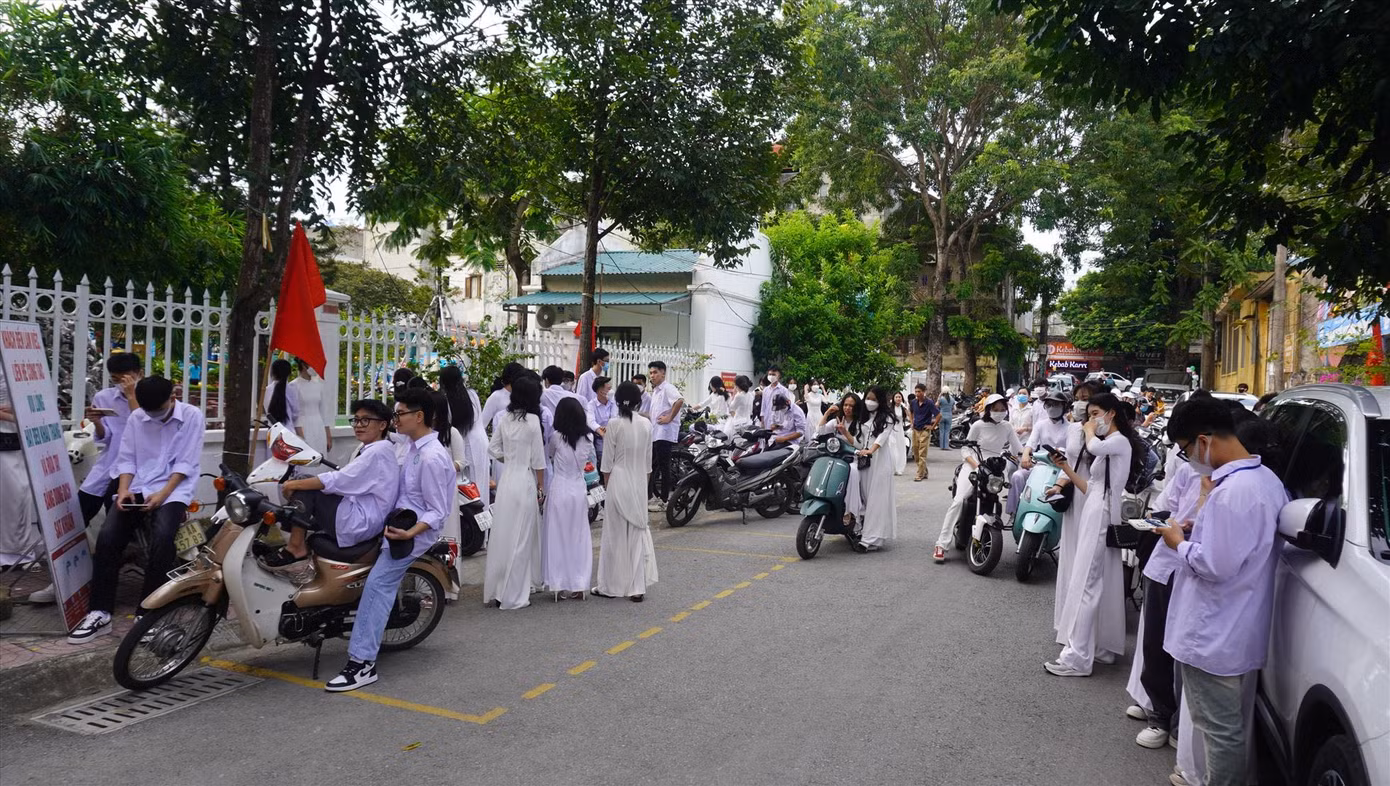 Được biết, sau thời gian đứng chờ, một thầy giáo trong trường đã ra khu vực cổng và yêu cầu các bạn học sinh ra về, không tụ tập trước cổng trường. (Ảnh: Q.D)