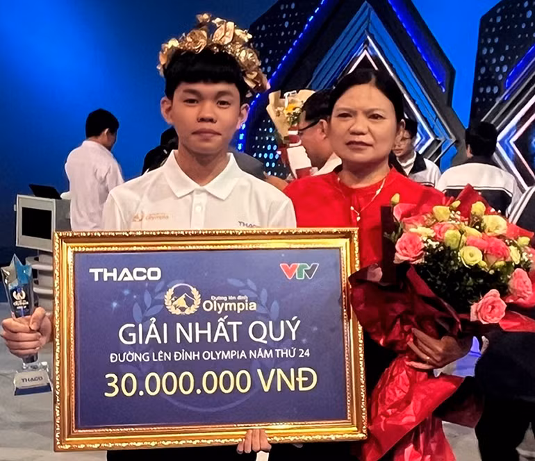 Cô Trần Thị Lệ Thủy, Hiệu trưởng nhà trường tặng hoa chúc mừng bạn Trần Trung Kiên sau khi giành vòng nguyệt quế. Ảnh: Báo Phú Yên