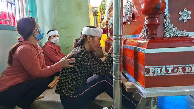 Mẹ của Ng., người ngồi gần quan tài đeo khăn tang khóc thương con. (Ảnh: Lâm Thiên)