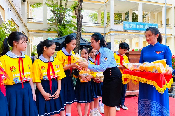 Chị Hồ Thị Thu Thanh, Phó Bí thư Tỉnh đoàn, Chủ tịch Hội đồng Đội tỉnh trao quà Hội đồng Đội Trung ương cho các em đội viên.
