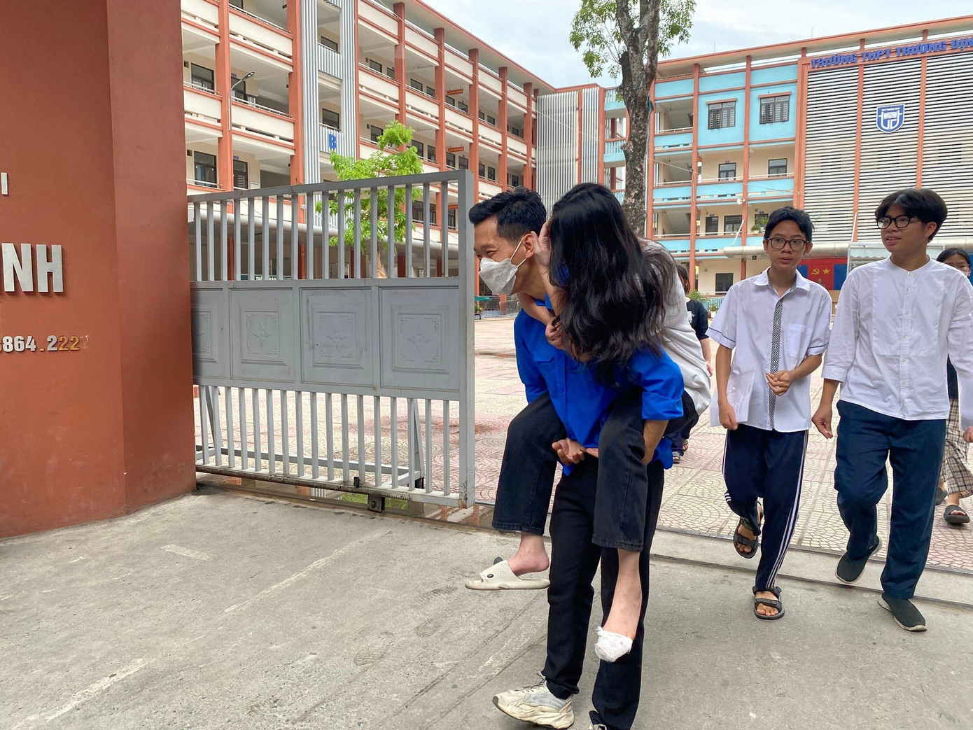 Một bạn thí sinh bị đau chân được hỗ trợ cõng vào phòng thi. Một bạn thí sinh bị đau chân được hỗ trợ cõng vào phòng thi.