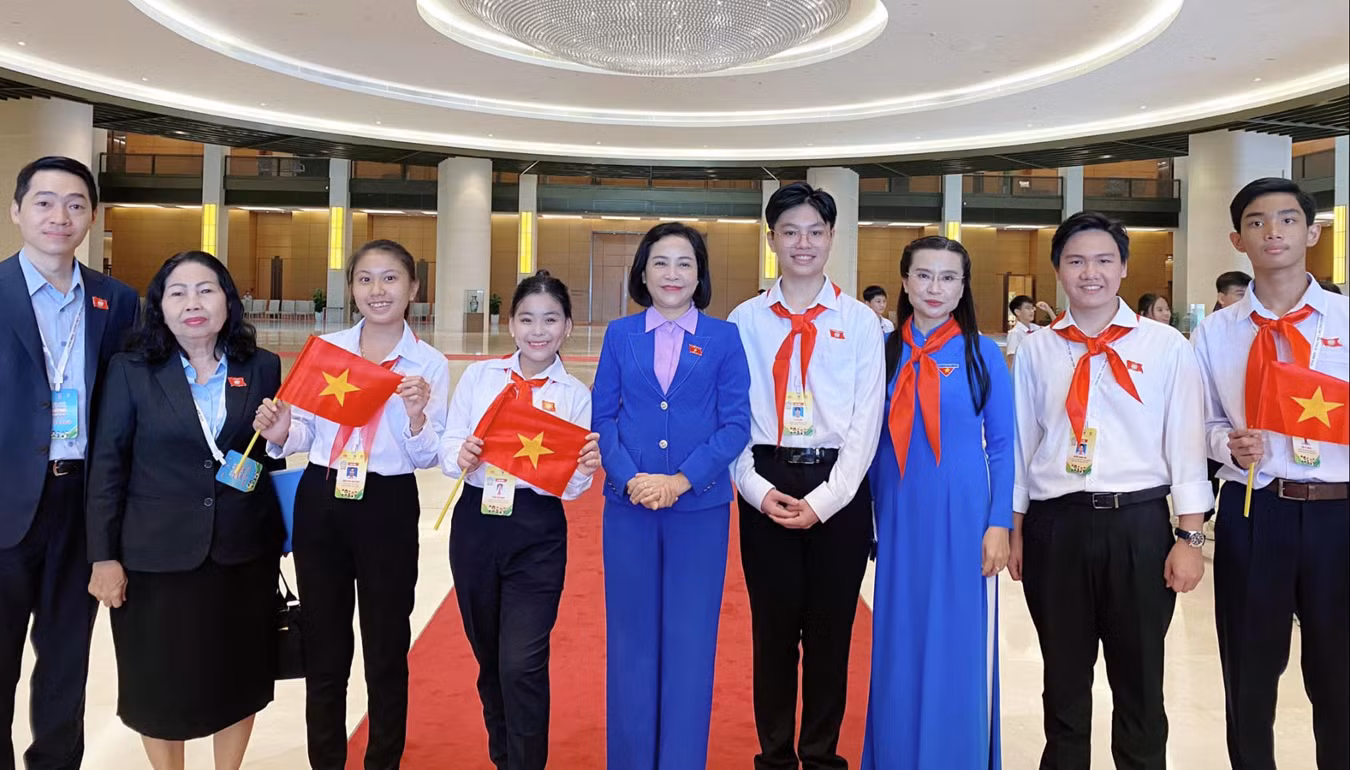 Phan Bảo Ngọc chụp ảnh lưu niệm cùng cô Nguyễn Thị Thanh - Phó Chủ tịch Quốc hội, chị Nguyễn Phạm Duy Trang - Chủ tịch hội đồng Đội T.Ư, luật sư Trần Thị Ngọc Nữ - Hội Bảo vệ quyền trẻ em TP.HCM và các đại biểu Phiên họp giả định Quốc hội trẻ em chụp tại Tòa nhà Quốc hội.