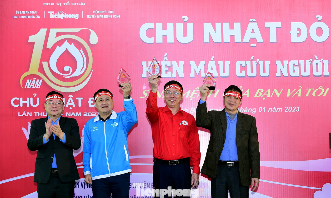 Nhà báo Lê Xuân Sơn tặng biểu trưng chương trình Chủ nhật Đỏ tới các đơn vị có nhiều đóng góp vào chương trình hiến máu. (Ảnh: Xuân Tùng)