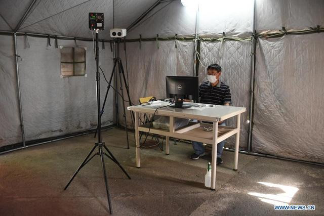 Nhân viên kiểm tra thân nhiệt tại địa điểm thi tuyển sinh đại học ở Bắc Kinh ngày 5/6/2021. (Ảnh: Tân Hoa Xã)