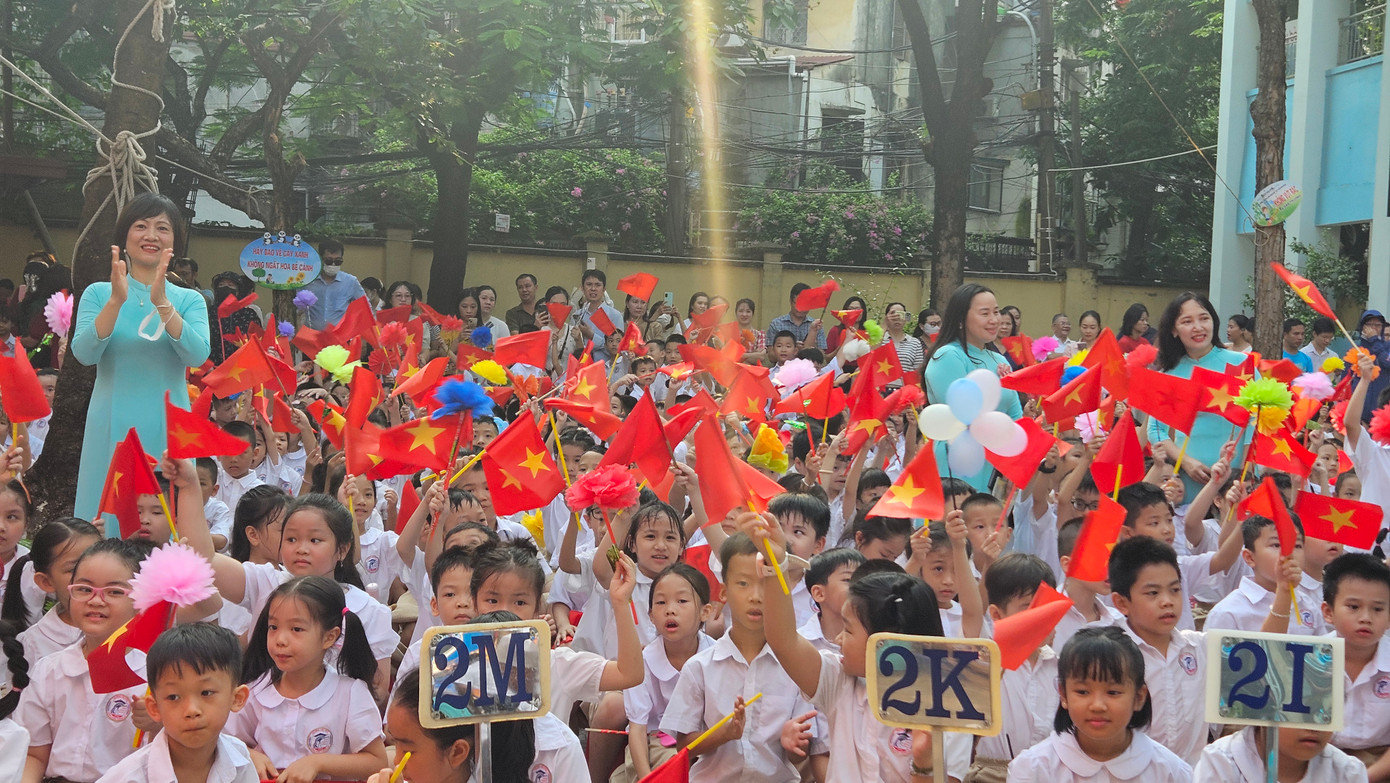 Các bạn học sinh vẫy cờ hoa bên cạnh những tràng pháo tay.